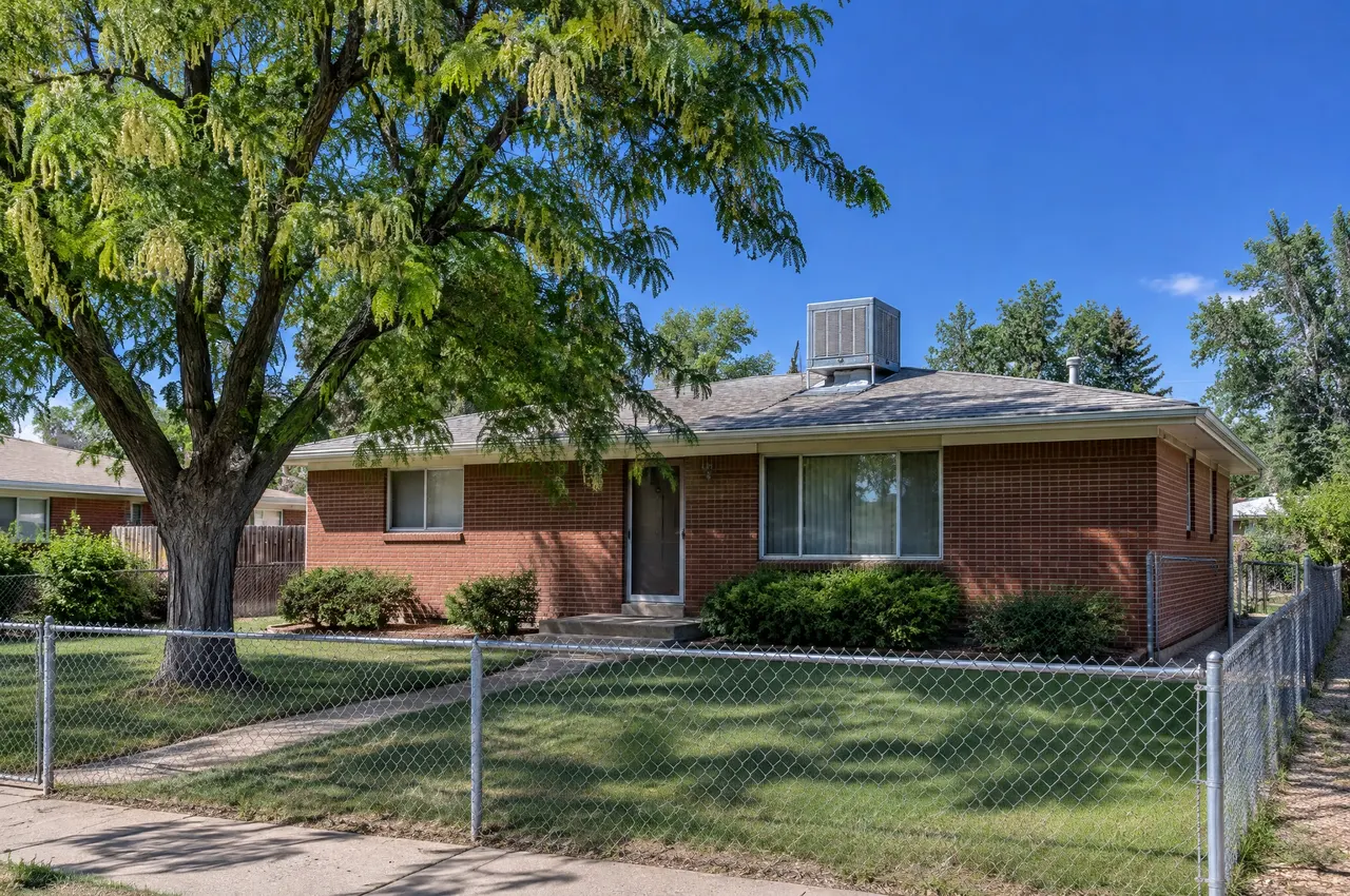 1950s single-story brick ranch in an older Aurora neighborhood with an evaporative swamp cooler on the roof
