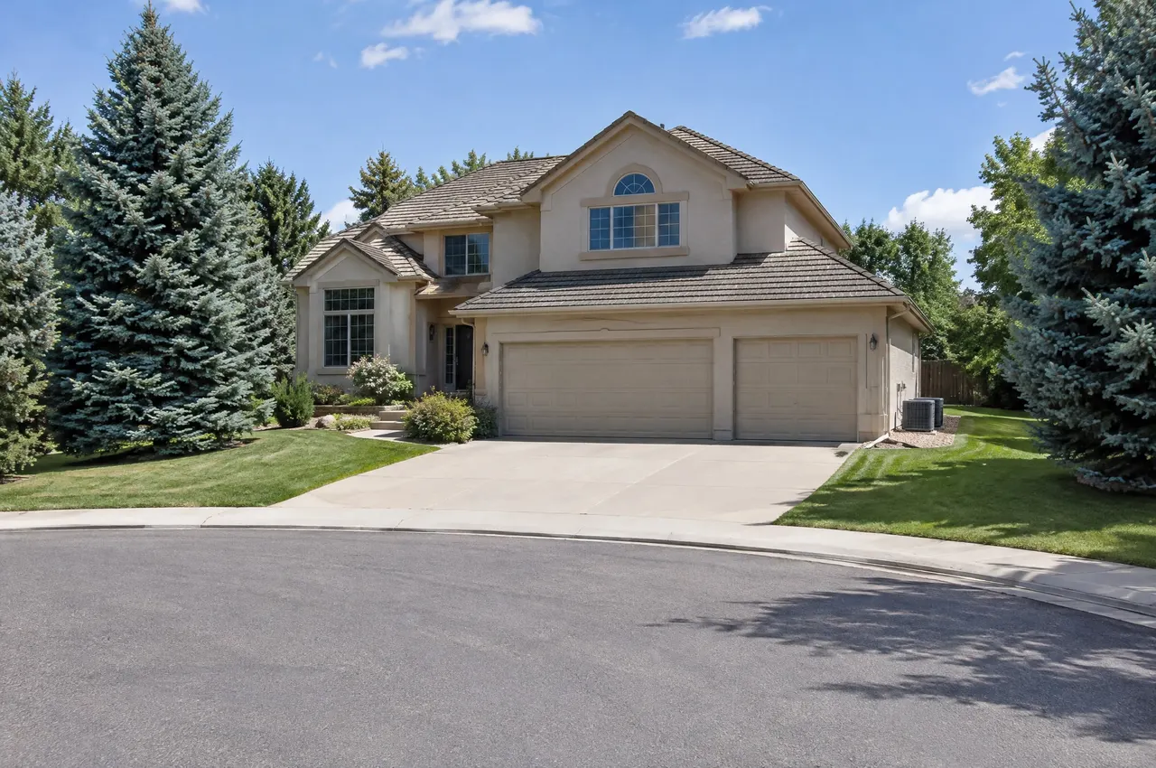 1990s two-story house with a three-car garage on a cul-de-sac in Centennial, two air conditioners along the side yard