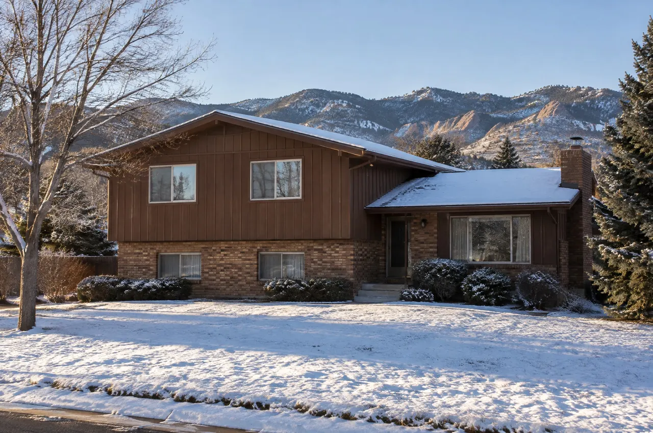 1970s tri-level house with wood siding and a brick lower level in Littleton, the foothills in the distance
