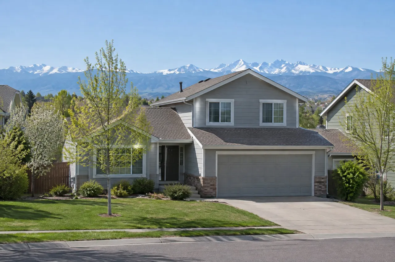 1980s two-story house in Westminster with snow-capped mountains on the horizon