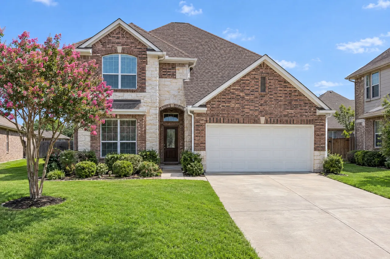 Two-story brick and stone home in Round Rock with a new weathered wood architectural shingle roof